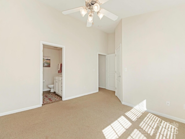 unfurnished bedroom featuring light colored carpet, baseboards, and connected bathroom