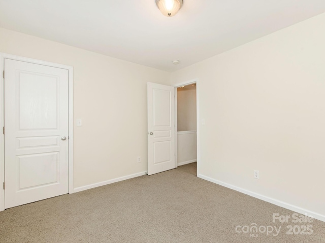 unfurnished room featuring carpet flooring and baseboards