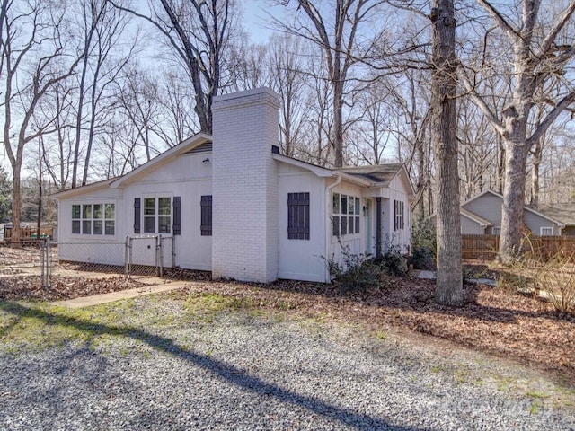 view of home's exterior with a chimney and fence