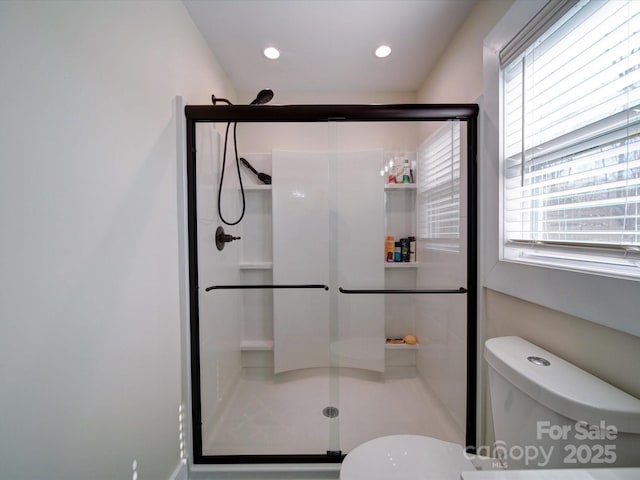 bathroom with a stall shower, toilet, and recessed lighting