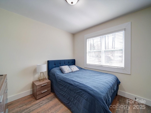 bedroom with baseboards and wood finished floors