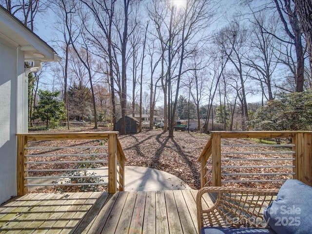 wooden deck featuring a storage unit and an outdoor structure