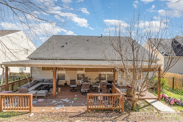 rear view of property featuring roof with shingles, fence, a deck, and an outdoor hangout area