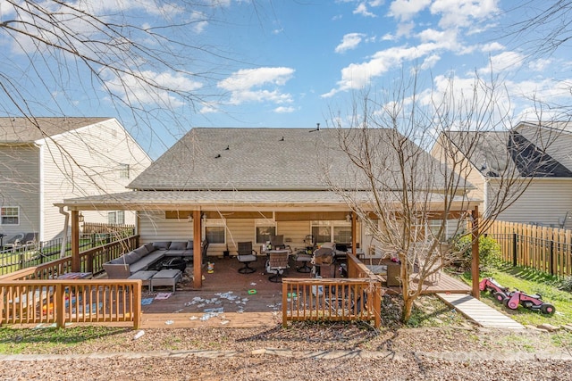 rear view of property featuring roof with shingles, fence, a wooden deck, and an outdoor hangout area