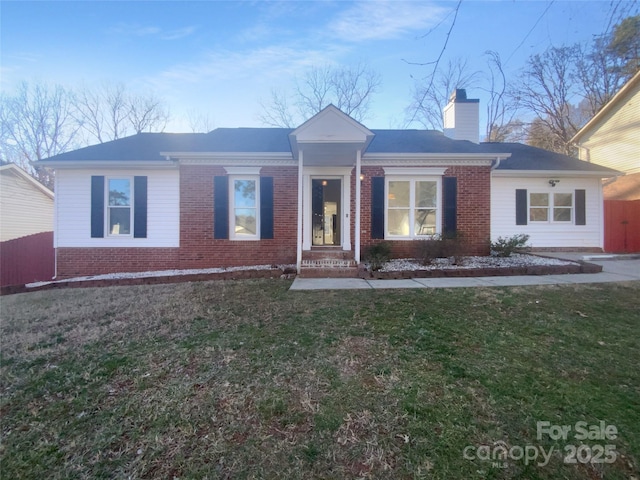 ranch-style house with a front yard, a chimney, and brick siding