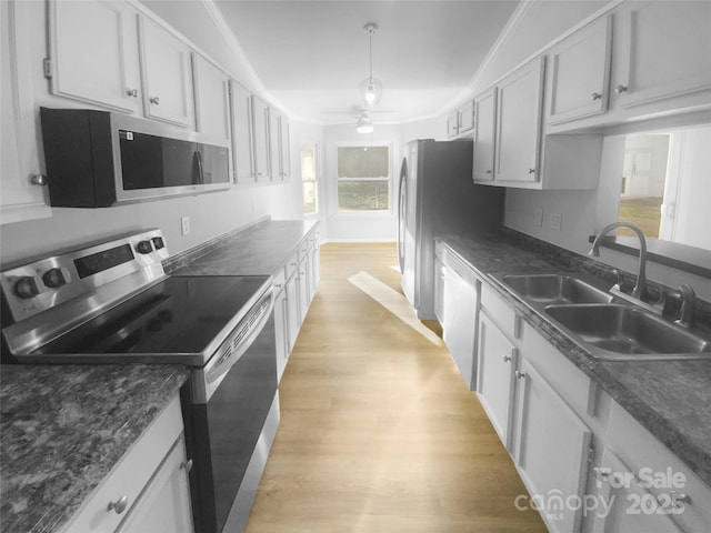 kitchen featuring light wood-type flooring, appliances with stainless steel finishes, white cabinets, and a sink