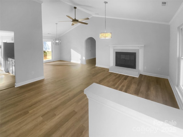 unfurnished living room featuring arched walkways, lofted ceiling, dark wood-type flooring, a fireplace, and visible vents