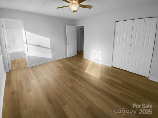 unfurnished bedroom featuring a ceiling fan, a closet, baseboards, and wood finished floors