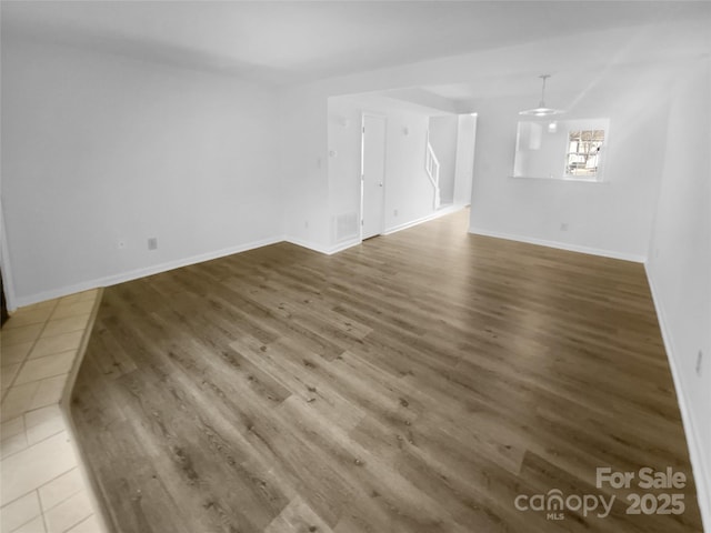 interior space with visible vents, baseboards, and wood finished floors