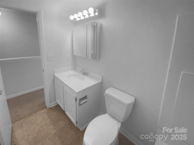 bathroom featuring baseboards, vanity, and toilet