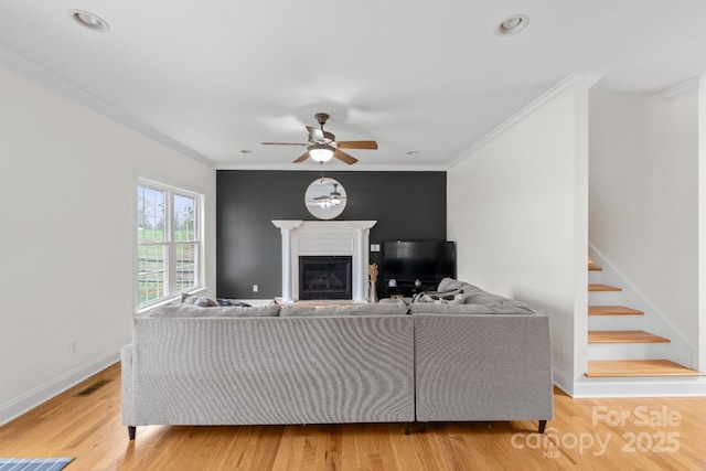 1919 46th Avenue Dr NE Unit 46, Hickory, NC 28601 - living room with ornamental molding, a ceiling fan, light wood-type flooring, a glass covered fireplace, and stairway