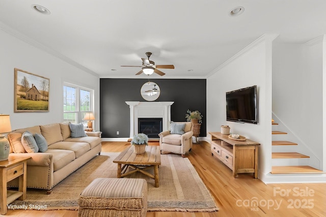 1919 46th Avenue Dr NE Unit 46, Hickory, NC 28601 - living room featuring crown molding, ceiling fan, light wood-style floors, a glass covered fireplace, and stairs