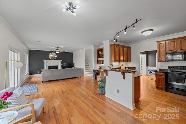 1919 46th Avenue Dr NE Unit 46, Hickory, NC 28601 - kitchen with black appliances, crown molding, a breakfast bar, a peninsula, and light wood-style floors