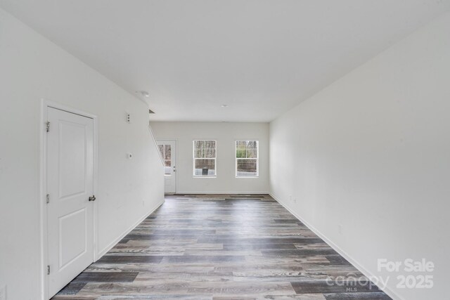empty room with baseboards and wood finished floors