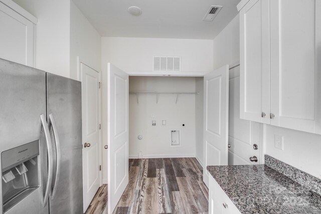 kitchen with white cabinets, visible vents, stainless steel refrigerator with ice dispenser, and dark stone countertops