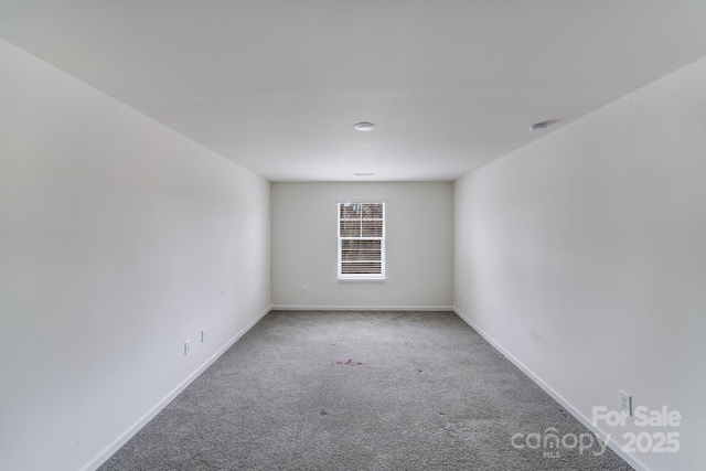 carpeted empty room with baseboards