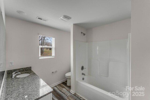bathroom with visible vents, toilet, shower / tub combination, wood finished floors, and vanity