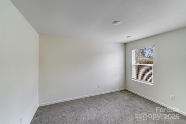 empty room featuring carpet flooring, visible vents, and baseboards