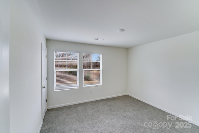unfurnished room featuring carpet floors, visible vents, and baseboards