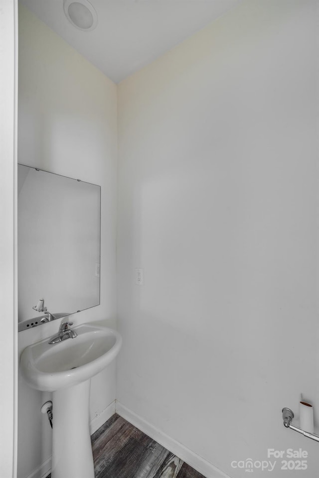 bathroom with a sink, baseboards, and wood finished floors