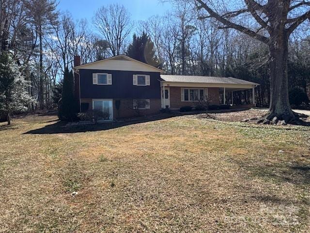 split level home featuring a chimney and a front lawn