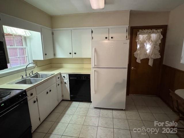 kitchen with light tile patterned floors, a sink, white cabinets, light countertops, and black appliances