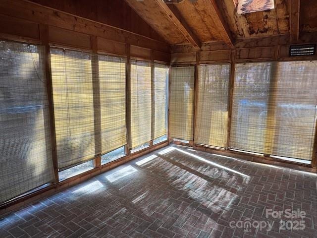 unfurnished sunroom featuring lofted ceiling