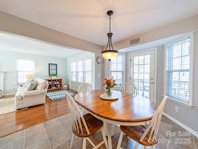 dining space featuring light wood finished floors and baseboards