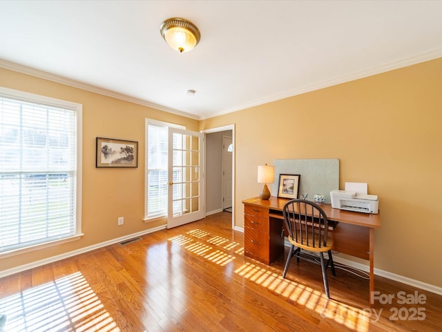 office area featuring light wood-style floors, visible vents, crown molding, and baseboards