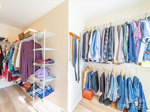 walk in closet with wood finished floors