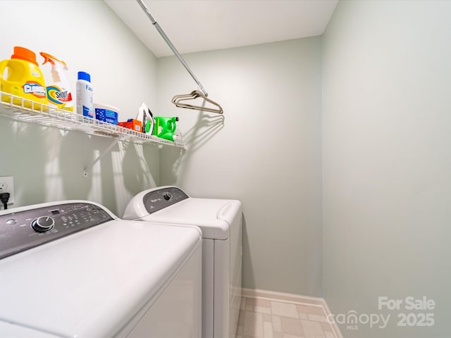 clothes washing area with laundry area, tile patterned floors, washing machine and dryer, and baseboards