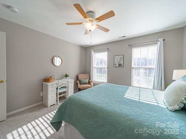 bedroom with light carpet, ceiling fan, visible vents, and baseboards