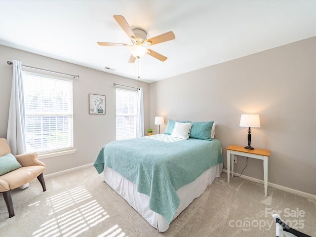 bedroom with visible vents, a ceiling fan, light colored carpet, and baseboards