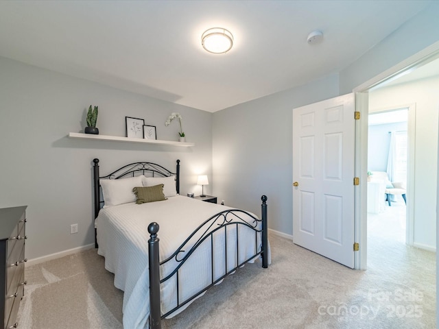 bedroom featuring light colored carpet and baseboards