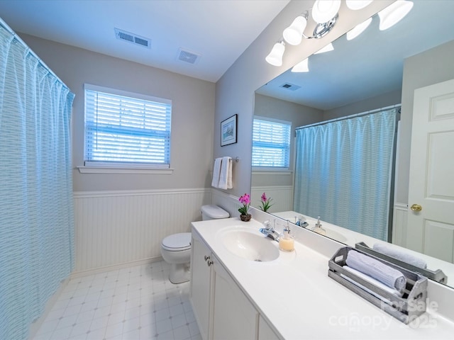 bathroom featuring a wainscoted wall, visible vents, and vanity