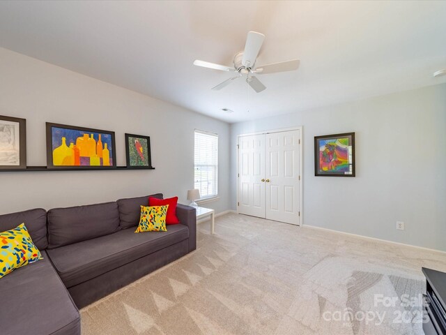 living room with light carpet, ceiling fan, visible vents, and baseboards