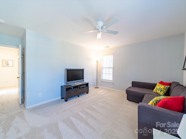 living room featuring light carpet, ceiling fan, and baseboards