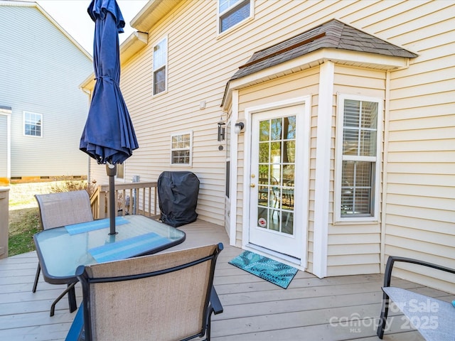 wooden terrace with area for grilling and outdoor dining space