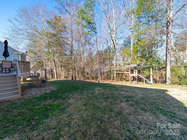 view of yard featuring a playground and a wooden deck