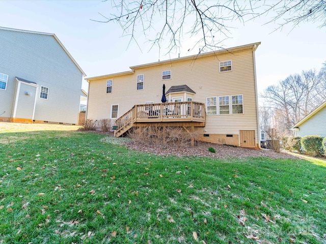 rear view of property featuring crawl space, a wooden deck, and a lawn