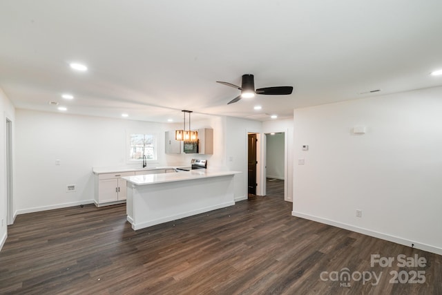 209 Palmer St, Shelby, NC 28150 - kitchen with a peninsula, a sink, light countertops, stainless steel electric stove, and dark wood-style floors