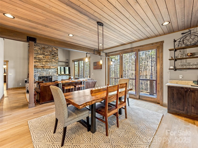 103 Duck Hope Dr, Hendersonville, NC 28739 - dining room featuring light wood-type flooring, wood ceiling, a wealth of natural light, and a stone fireplace