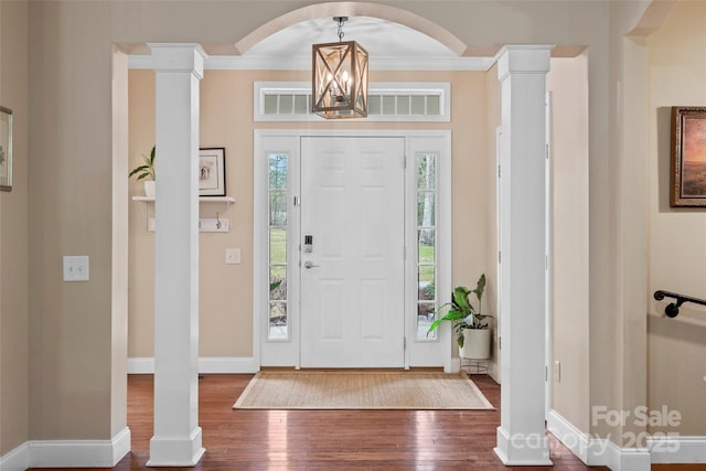 foyer entrance with visible vents, baseboards, wood finished floors, crown molding, and ornate columns