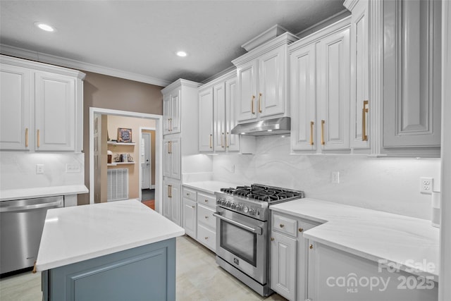 kitchen with tasteful backsplash, white cabinets, appliances with stainless steel finishes, under cabinet range hood, and recessed lighting