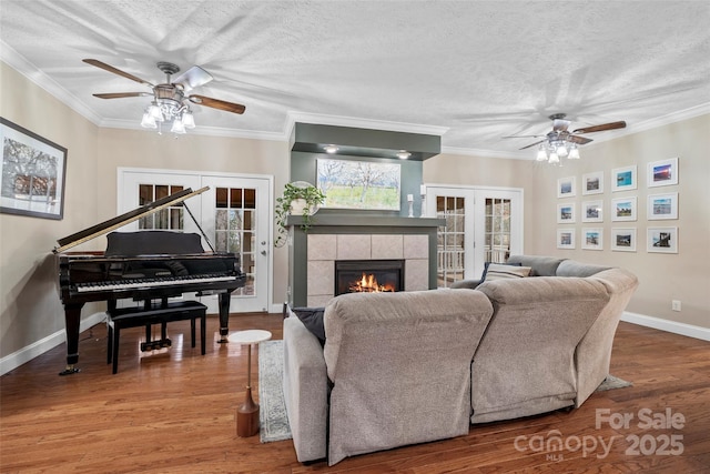 living room featuring french doors, crown molding, a textured ceiling, and wood finished floors