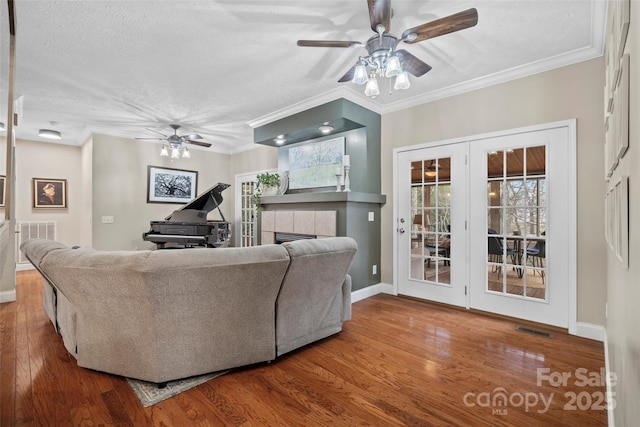 living area with a fireplace, wood finished floors, visible vents, and a ceiling fan