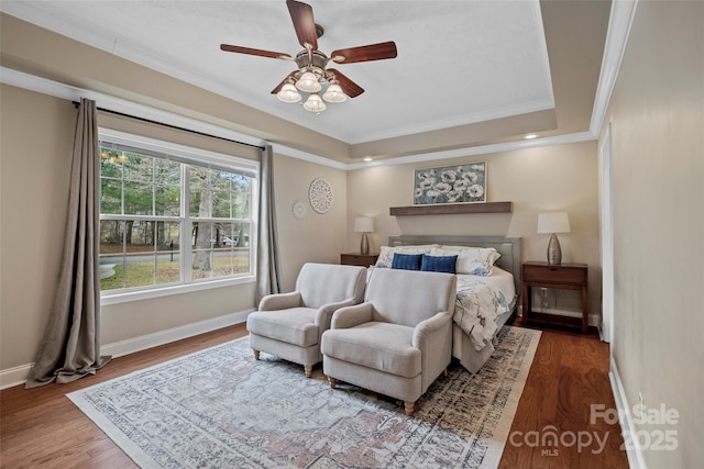 bedroom with ornamental molding, baseboards, and wood finished floors