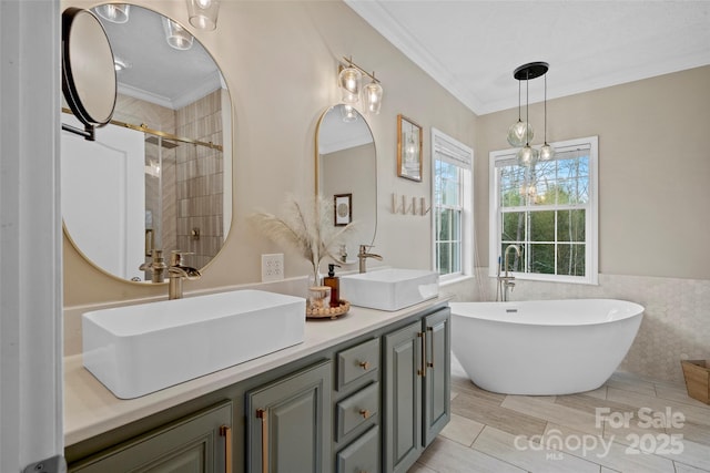 full bath featuring double vanity, crown molding, a freestanding bath, and a sink