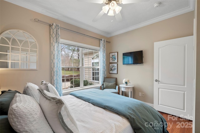 bedroom featuring a ceiling fan, crown molding, and wood finished floors