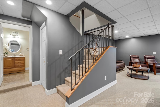 stairway with carpet floors, recessed lighting, visible vents, a drop ceiling, and baseboards